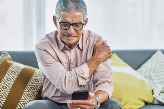 Man looking up urgent care centers on smart phone